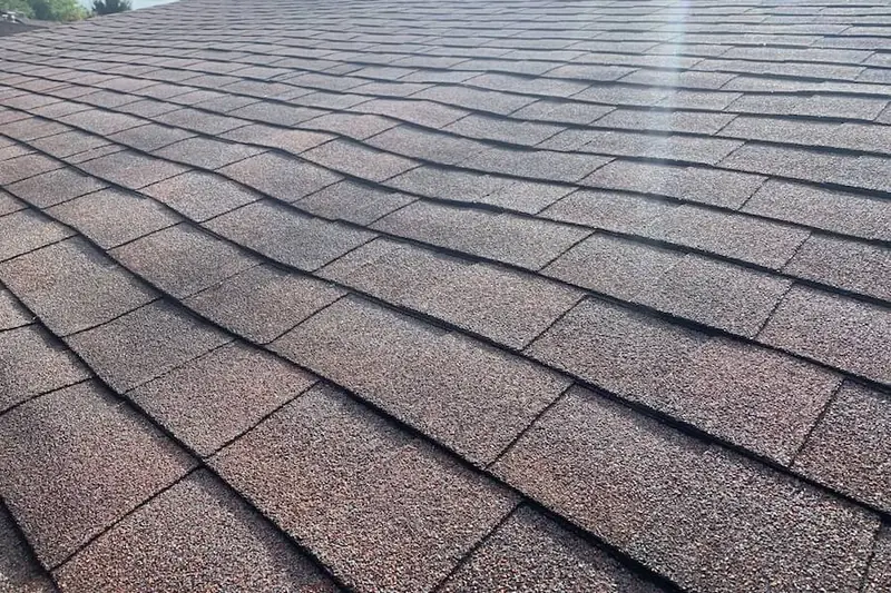 Shingle rows rippling unevenly across a roof