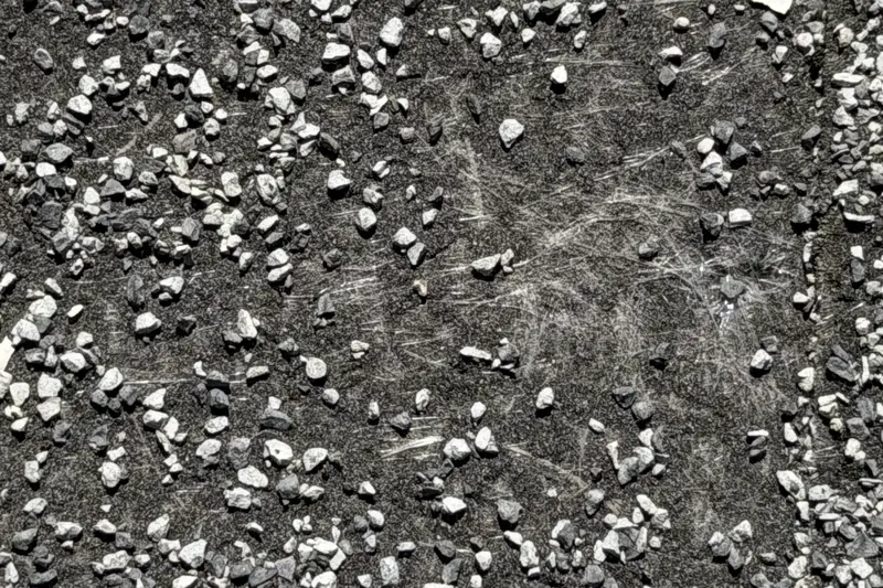 Close-up of a worn shingle with granules gone and the mat showing through